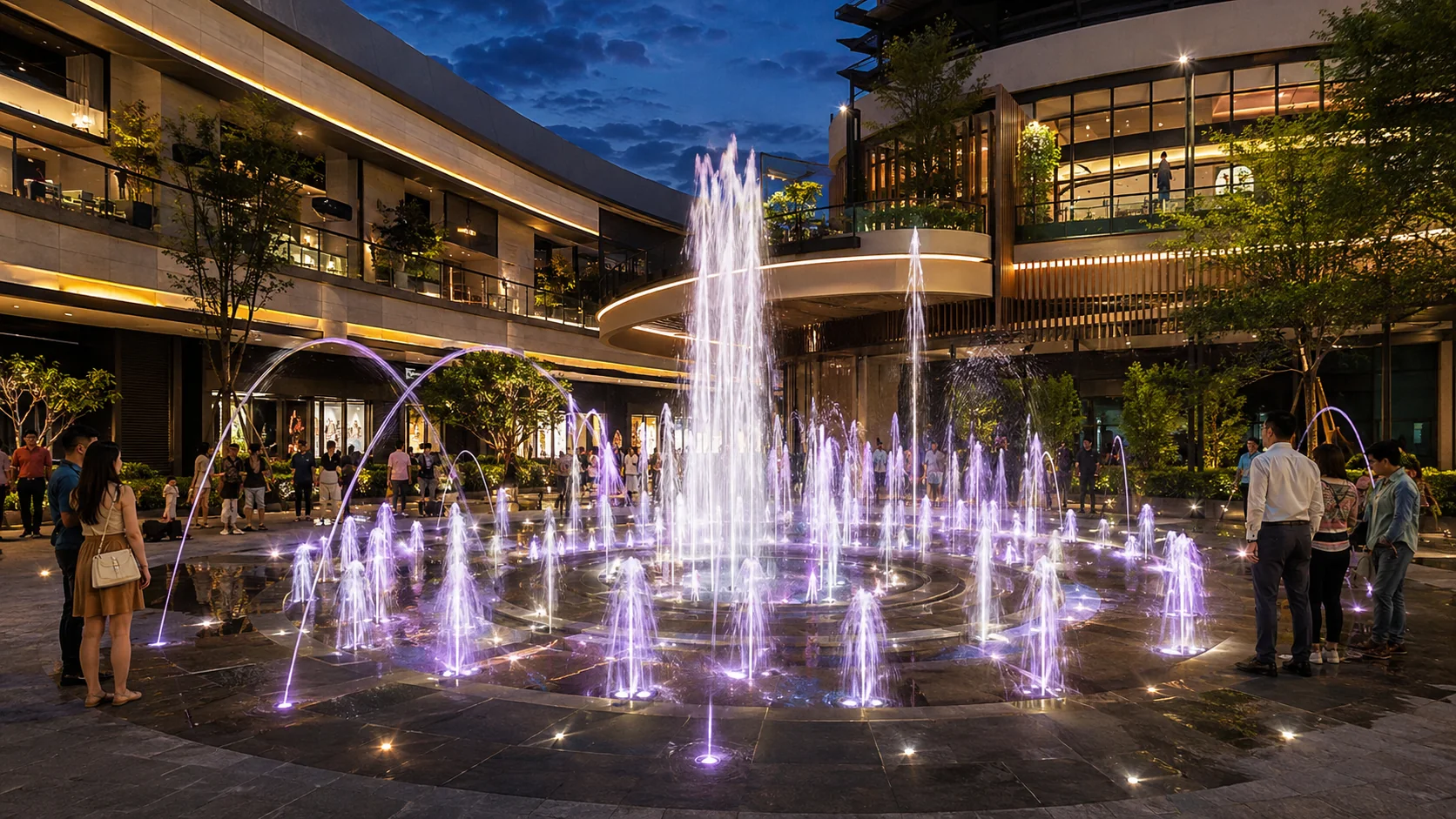 Fuente dinámica e interactiva iluminada en plaza comercial nocturna