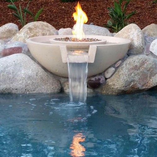 Fire bowl con llama central y cascada de agua hacia una alberca