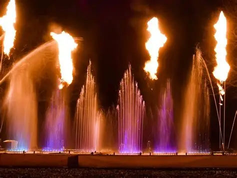 Fuente danzante nocturna con columnas de fuego y luz de colores
