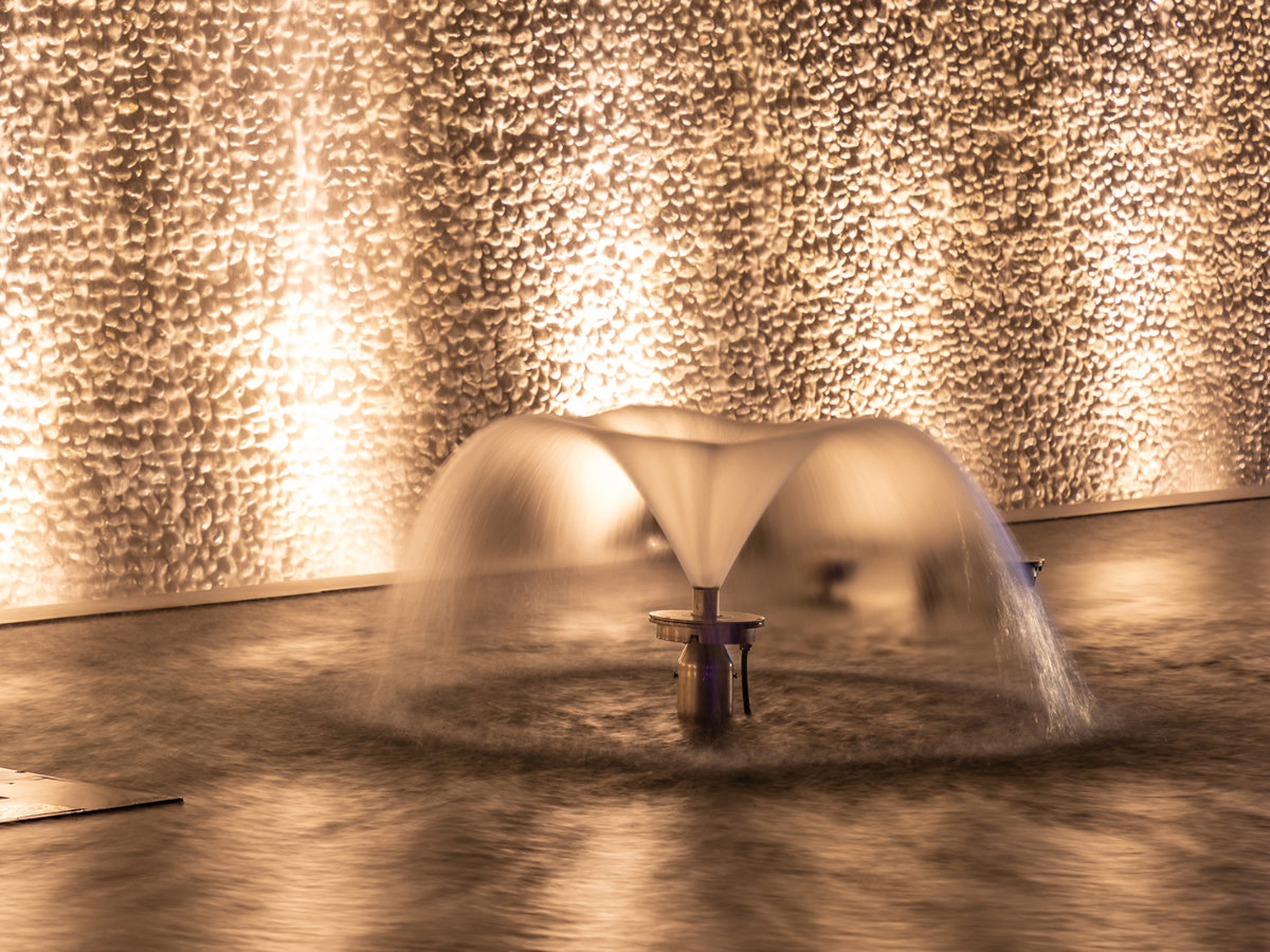 Fuente ornamental iluminada en espejo de agua